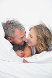 Cute middle aged couple under the duvet