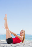 Athletic blonde doing pilates core exercise smiling at camera