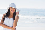 Beautiful brunette in white sunhat smiling at camera