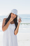 Happy brunette in white sunhat looking at camera