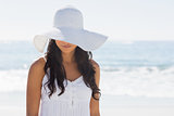 Beautiful brunette in white sunhat looking down