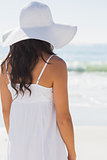 Pretty brunette in white sunhat looking at the sea