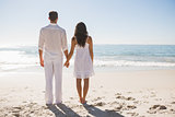 Attractive couple holding hands and watching the waves