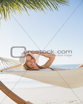 Smiling blonde relaxing on hammock