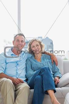 Cheerful couple relaxing on their couch