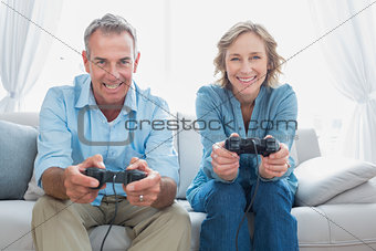 Happy couple playing video games together on the couch