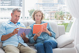 Content couple reading books on the couch