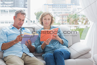 Content couple reading books on the couch