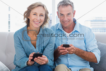 Happy couple using their smartphones