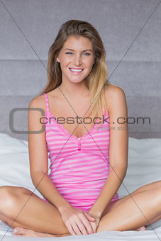Sultry blonde sitting on her bed