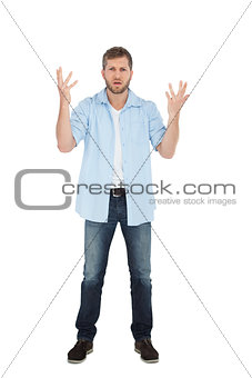 Handsome man posing with hands up and looking at camera