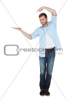 Handsome model holding laptop and pointing at it