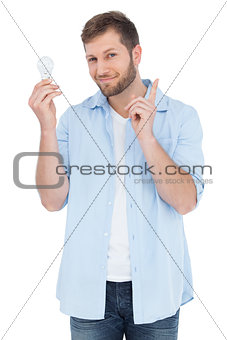 Charming model holding a bulb in right hand