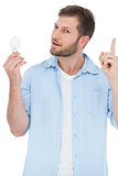 Sceptical model holding a bulb and getting idea