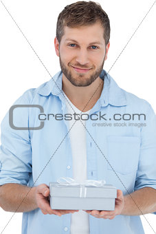 Handsome man holding a present looking at camera