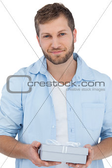Handsome man holding a gift looking at camera
