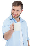 Smiling model offering a mug