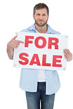 Trendy model holding a for sale sign