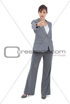 Serious businesswoman pointing at camera