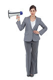 Serious businesswoman holding loudspeaker