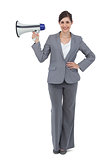 Smiling businesswoman holding loudspeaker