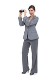 Astonished businesswoman posing with binoculars
