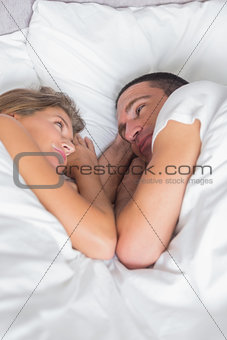 Cute couple lying together in bed