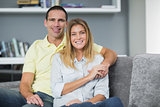Smiling young couple sitting on their couch