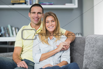 Smiling young couple sitting on their couch