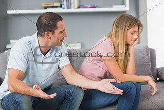 Couple sitting on the couch having an argument