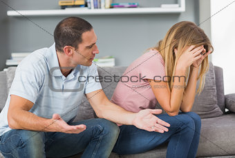 Couple sitting on the couch having a fight