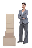 Smiling businesswoman posing with cardboard boxes