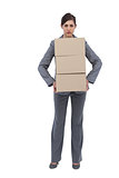 Serious businesswoman carrying cardboard boxes