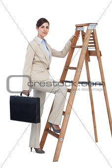 Businesswoman climbing career ladder with briefcase and looking at camera