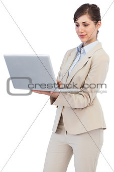 Confident businesswoman holding laptop