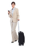 Confident businesswoman with suitcase and phone