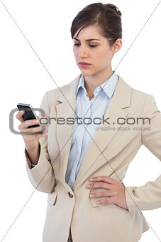Serious businesswoman posing with phone on right hand
