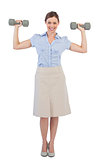 Strong businesswoman posing with dumbbells