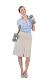 Happy businesswoman lifting dumbbells looking at camera