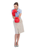 Attractive businesswoman posing with red boxing gloves