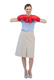 Cheerful businesswoman posing with red boxing gloves