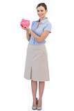 Cheerful businesswoman with piggy bank