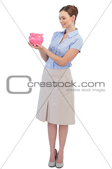 Happy businesswoman with piggy bank