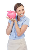 Cheerful businesswoman holding piggy bank