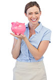 Happy businesswoman holding piggy bank