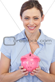 Pretty businesswoman holding piggy bank