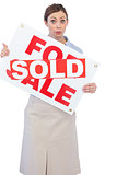 Estate agent showing for sale sign with sold sticker across it