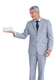 Handsome businessman holding gift on right hand