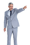 Handsome businessman pointing away
