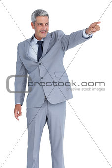 Handsome businessman pointing away